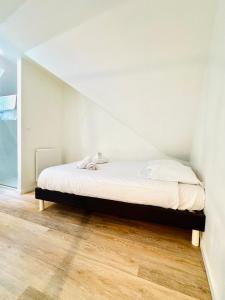 ein Schlafzimmer mit einem Bett in einer weißen Wand in der Unterkunft LE LAVADIÈRE - Joli duplex avec terrasse in Sèvres