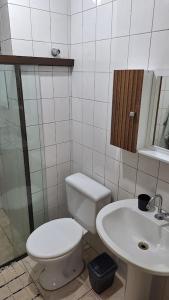 a bathroom with a toilet and a sink at Studio confortável e bem localizado in Foz do Iguaçu +14 photos