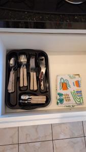 a black tray filled with utensils on a counter at Studio confortável e bem localizado in Foz do Iguaçu