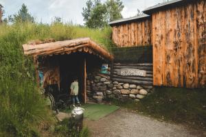a man standing outside of a building with a grass roof at Eventyrhyttene i Jotunheimen in Stuttgongfossen +11 photos