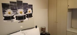 a room with a bed and a painting of flowers on the wall at Andros Guesthouses in Andros