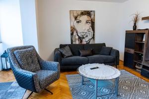 a living room with a couch and a chair at RUM Apartment in Cluj-Napoca