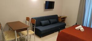 a room with a couch and a table and a desk at Andros Guesthouses in Andros