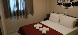 a bedroom with a bed with two towels on it at Andros Guesthouses in Andros