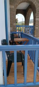 a porch with wooden tables and chairs on a balcony at Andros Guesthouses in Andros