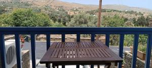 a wooden bench sitting on top of a balcony at Andros Guesthouses in Andros