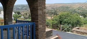 a balcony of a house with a blue railing at Andros Guesthouses in Andros