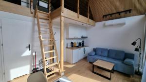 a living room with a loft bed and a blue couch at Jodłowe Zacisze in Lubkowo
