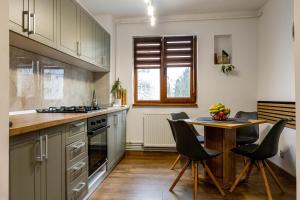 a kitchen with a table and chairs and a table and a counter at RUM Apartment in Cluj-Napoca