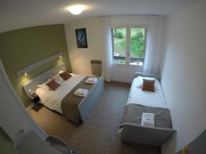 A bed or beds in a room at Hôtel Les Rives D'Allier