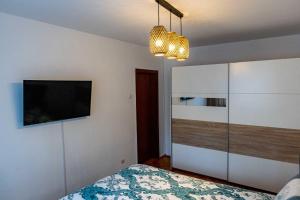 a bedroom with a bed and a tv on the wall at RUM Apartment in Cluj-Napoca