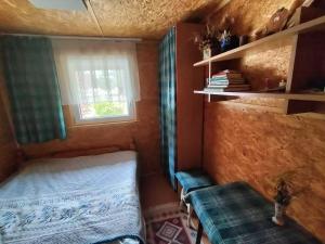 a small room with a bed and a window at Zielony domek na Kaszubach in Raduń