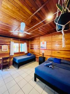 a room with two beds and wooden walls at Wasi la Punta 6 Starlink 2min walk to the beach in Brisas de Zicatela