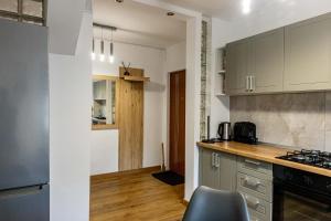 a kitchen with white cabinets and a counter top at RUM Apartment in Cluj-Napoca