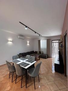 un soggiorno con tavolo, sedie e divano di Private House Velipoj a Velipojë