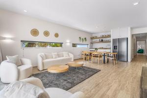 a living room with white furniture and a table at Boutique Hotel Bougainvillea in Kralendijk
