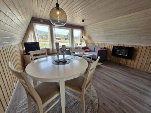 a room with a table and chairs and a living room at Fjellhytte i Valdres, rett ved nasjonalpark og turstier in Robøle