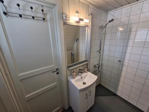 a bathroom with a sink and a mirror and a door at Fjellhytte i Valdres, rett ved nasjonalpark og turstier in Robøle