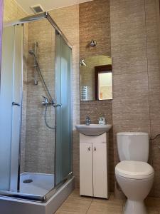 a bathroom with a shower and a toilet and a sink at Apartamenty Amber Wyspa in Gdańsk +47 photos