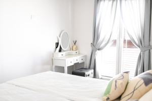 a white bedroom with a bed and a window at Lavica Beach apartment in Podstrana