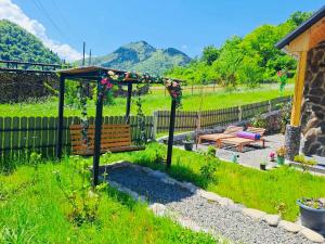 a garden with a bench and a gazebo at Woodlandia Borjomi with Hot Tub and Private Garden in Borjomi