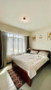 une chambre avec un grand lit et une fenêtre dans l'établissement Elevated Staycation BGC Venice Grand Canal, à Manille