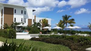 a resort with a pool and chairs and umbrellas at Villasun Seafront Apart at CapOuest in Flic-en-Flac