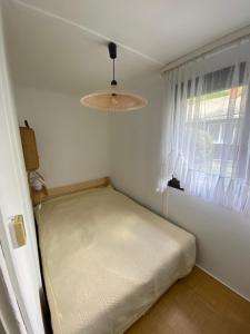 a small bedroom with a bed and a window at Romantic bungalow in Balatonudvari