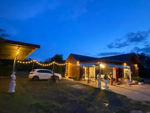 une voiture garée devant une maison éclairée dans l'établissement Alisa Villa, Ubon Cottage, à Ban Pla Duk