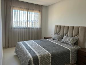 a bedroom with a bed with a large window at Rmilat Garden N8 vue sur la piscine in Cabo Negro