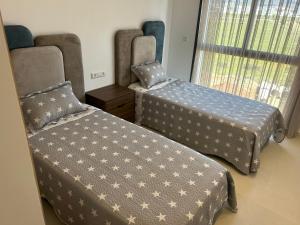 a room with two beds and a window at Rmilat Garden N8 vue sur la piscine in Cabo Negro