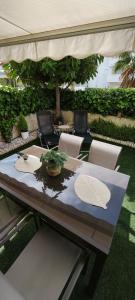 una mesa de madera con sillas y una sombrilla en Denia Beach Apartment Jardín privado y piscina, en El Verger
