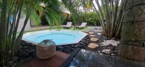 a swimming pool with a vase sitting in a yard at Love Lodge Guadeloupe - Love Room Romantique Saint Francois in Saint-François