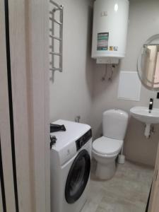 Un baño con lavadora y un inodoro. en Люкс апартаменты -Центр, en Mykolaiv