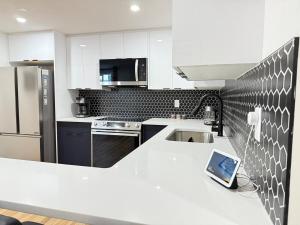 カルガリーにあるRustic Rocky Retreatのカウンターにタブレットが置かれた白いキッチン