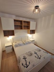 a bedroom with a bed with an anchor on it at Apartments Amfora in Gdinj