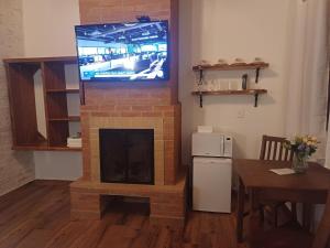 a living room with a fireplace with a tv on top at Refugio Victoria in Monte Verde +19 photos