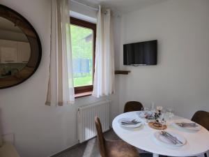a dining room with a white table and a window at Apartment Hosner in Lepena