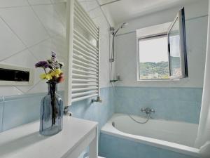 a vase with flowers on a counter in a bathroom at Cottage Fabrizio apartment surrounded by greenery in the center in Sorrento +15 photos