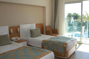 a hotel room with two beds and two windows at Annabella Diamond Hotel - All Inclusive in Avsallar