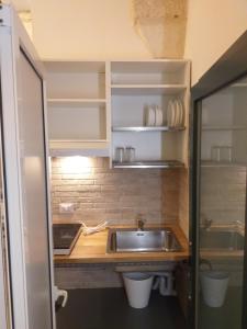 uma pequena cozinha com uma pia e um balcão em Salento Studio em Calimera