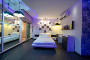 a purple bedroom with a bed and a mirror at Luxury Three bedroom Apt Al Yasmin in Riyadh