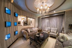 a living room with a couch and chairs and a chandelier at Luxury Three bedroom Apt Al Yasmin in Riyadh
