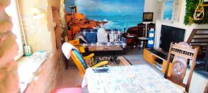 a living room with a table and a television at Coeur de granit rose, meublé alliant le charme de l'authentique breton et du confort, classé 3 étoiles, à 5mn de 13 plages de la réputée cote de granit rose in Trégastel