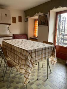 a kitchen with a table with a plaid table cloth on it at Casa Vanda in Châtillon +7 photos