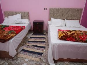 two beds sitting next to each other in a room at برج اللؤلؤ Residential tower in Siwa
