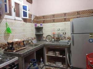 a kitchen with a sink and a refrigerator at برج اللؤلؤ Residential tower in Siwa