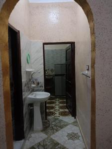 a bathroom with a white sink and a mirror at برج اللؤلؤ Residential tower in Siwa
