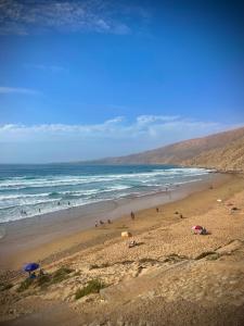 un grupo de personas en una playa con sombrillas en Teldi Valley Beach, en Tildi