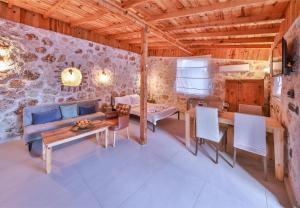 a living room with a couch and a table and chairs at Bademlique Stone Rooms in Kaş